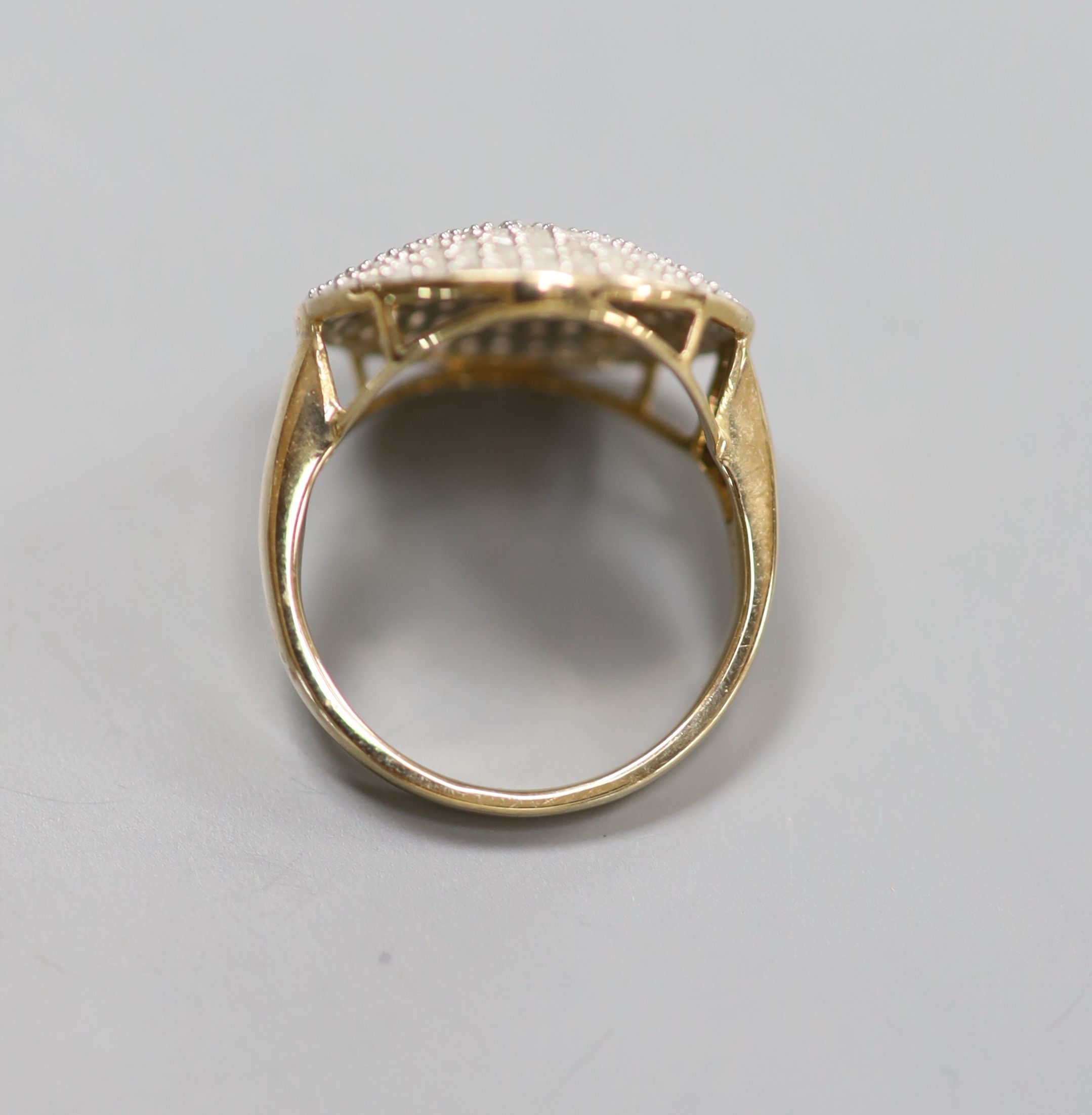 A modern 9kt and pave set diamond chip circular dress ring, size P, gross weight 4.8 grams.